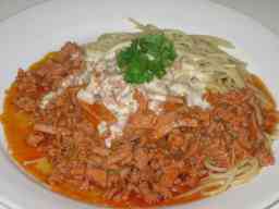 Juustokastike bolognalaisen aidon jauhelihakastikkeen kera lautasella