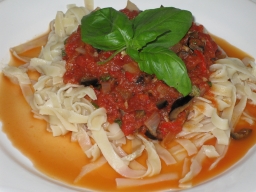 Puttanesca tagliatellen kanssa lautasella