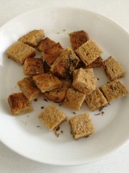 Yrttileipäkuutiot paahtoleivästä lautasella