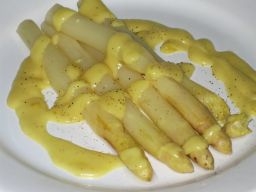 Keltainen tankoparsa samppanjakastikkeen kera lautasella