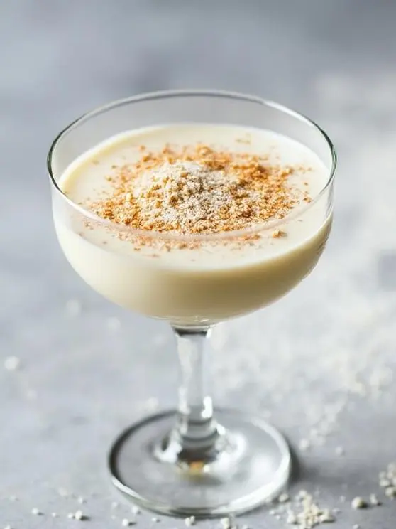 Alexander-cocktail cocktaillasissa, pinnalla raastettua muskottipähkinää