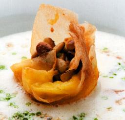 Cheddarjuustotimbaali ja valkosipulikeitto lautasella