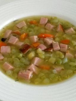 Lautasellinen hernekeittoa, jossa palvilihaa ja porkkanaa.
