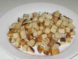 Paahdetut leipäkuutiot lautasella