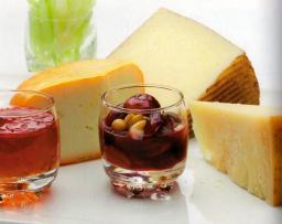 Näin kokoat juustotarjottimen, tarjottimella useampi juusto ja lasi täynnä pähkinöitä