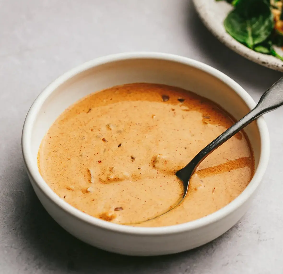 Paprikakastike kulhossa, kermainen kastike jossa herkkusieniä, tomaattia ja vihreitä oliiveja