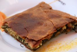 Spana kopita-pinaatti-juustopiirakka lautasella tarjoiltuna