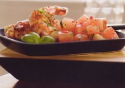 Suuret katkaravut melonisalaatin kera tarjoilualustalla