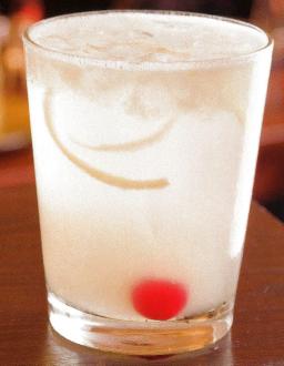 Tom Collins -pitkä drinkki lasissa jääpalojen ja sitruunaviipaleen kanssa.