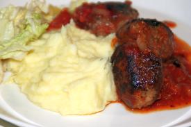 Valkosipuliperunamuhennosta tomaattikastikkeessa italialaisten lihapullien kera