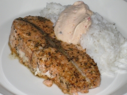 Yrttiset lohimedaljongit keitetyn riisin sekä paprika-chili crème fraichen kanssa lautasella